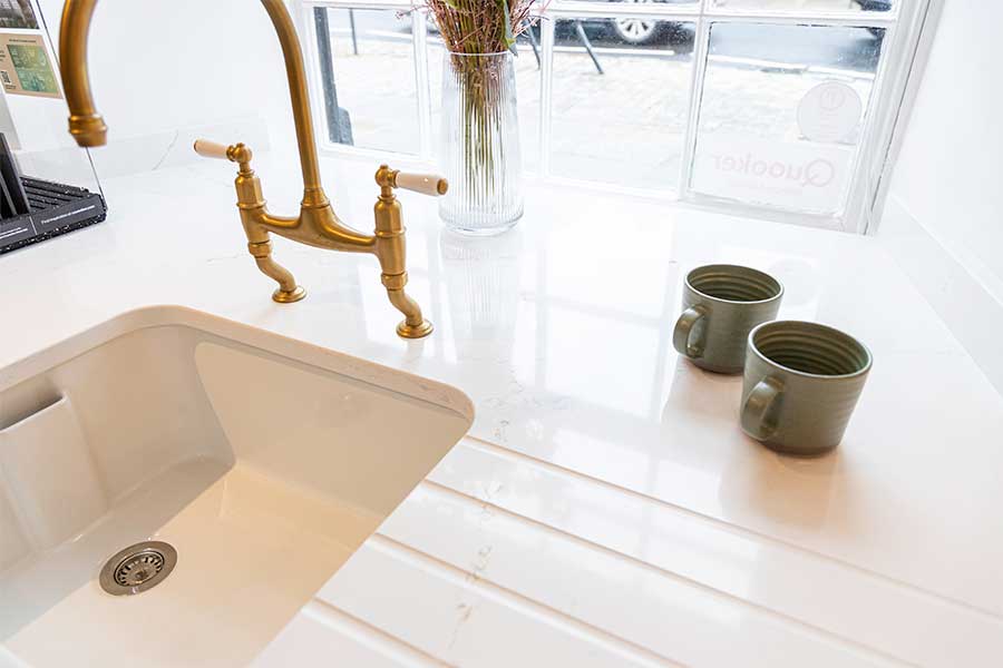 Bespoke Silestone quartz worktops with recess for a butler's sink and machined drain groves produced by Sussex Stoneworks for the showroom at Claremont Kitchens & Interiors in Midhurst